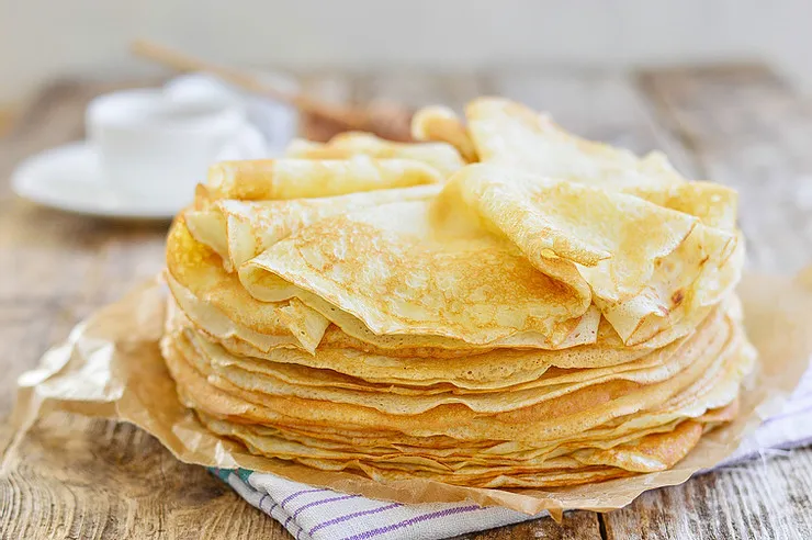 Electric crepe maker with a thin crepe cooking on the surface
