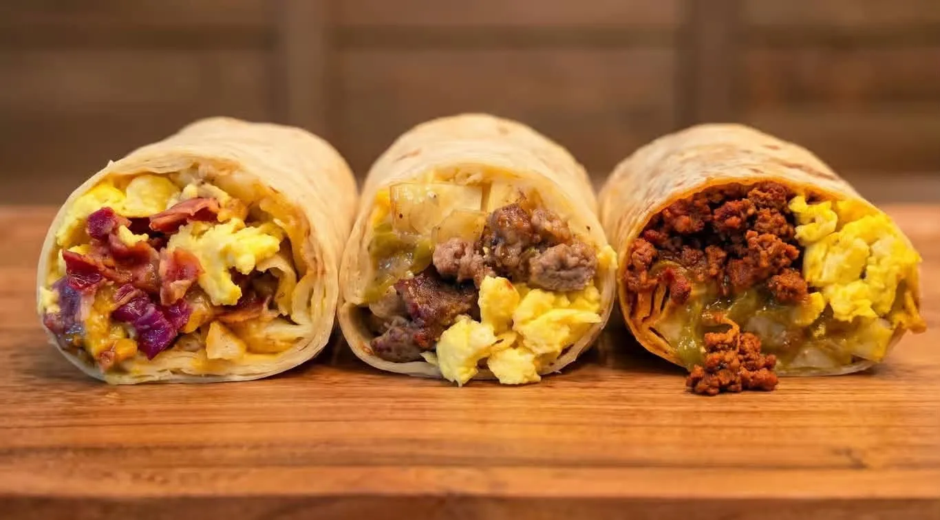 Blackstone breakfast burrito stuffed with eggs, crispy potatoes, bacon, and cheese