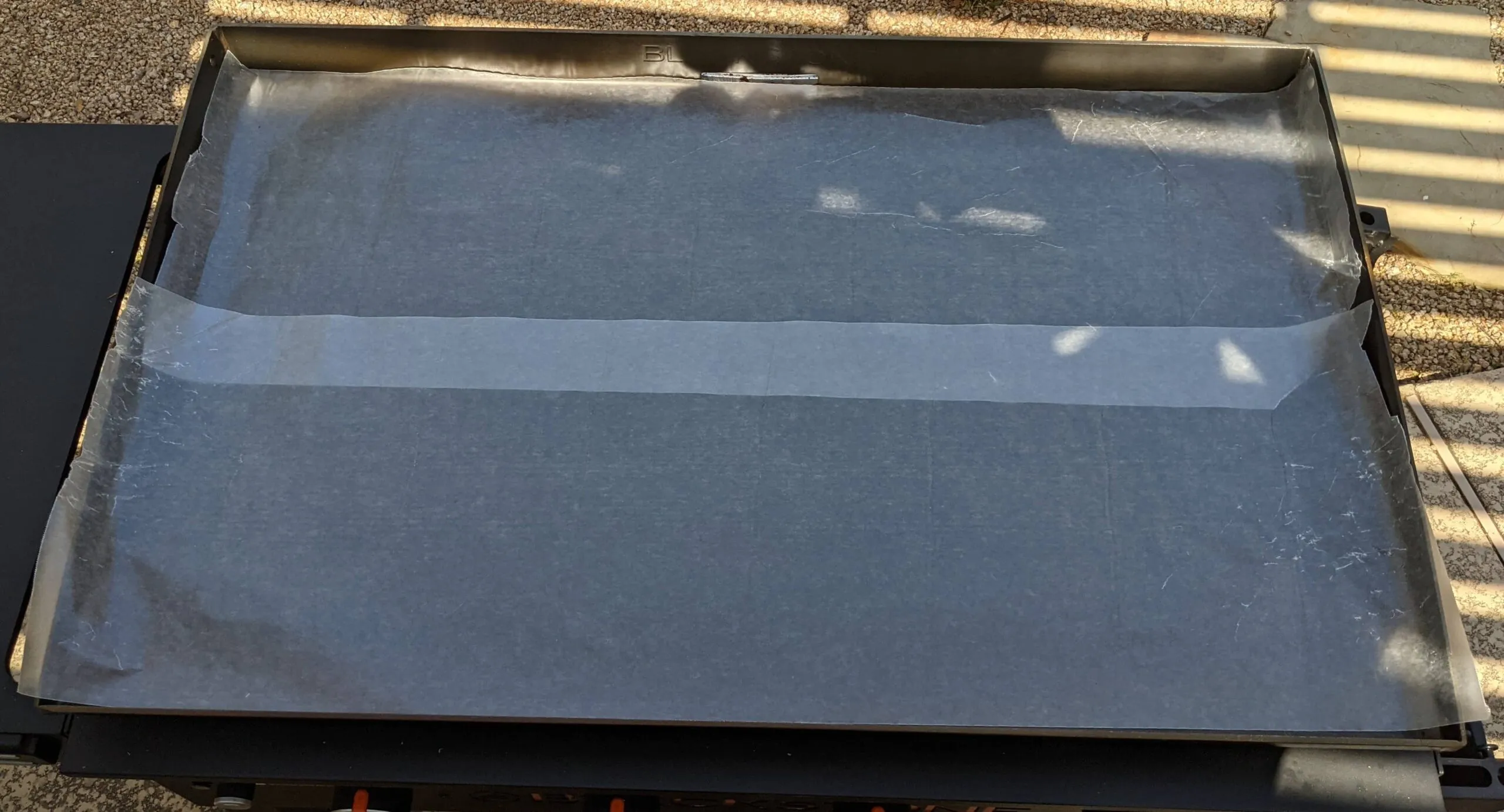 Blackstone griddle with wax paper laid across the cooktop during storage