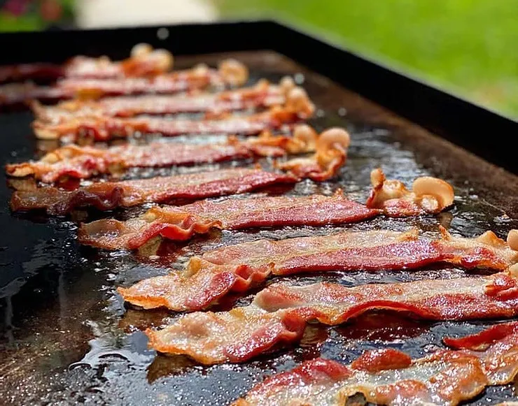 Bacon cooking on a Blackstone griddle