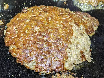 Smash burger after flip showing the dark brown crust