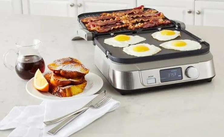 Electric contact griddler with ribbed plates open on a countertop