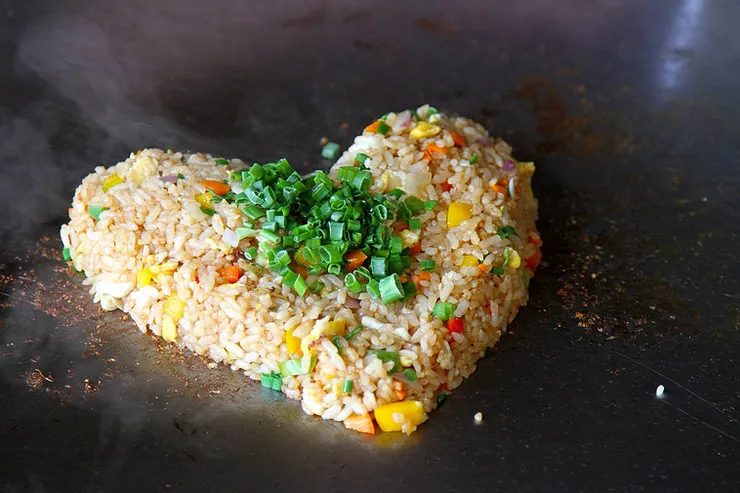 Blackstone hibachi chicken with fried rice and vegetables on a griddle