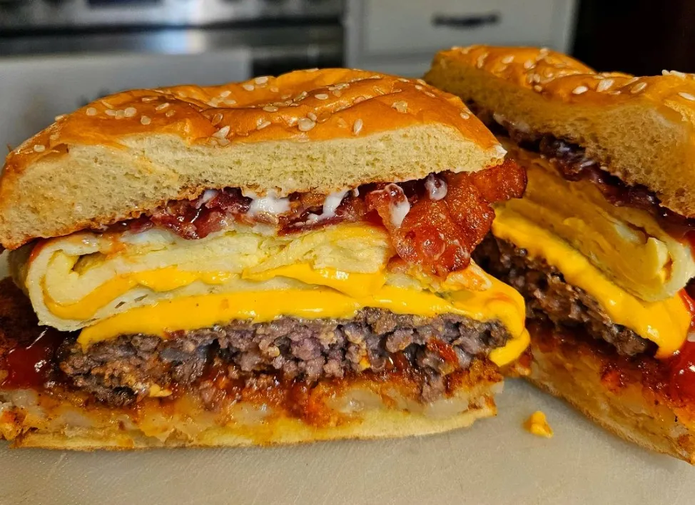 Blackstone breakfast burger with smash patty, fried egg, bacon, and melted cheese on a brioche bun