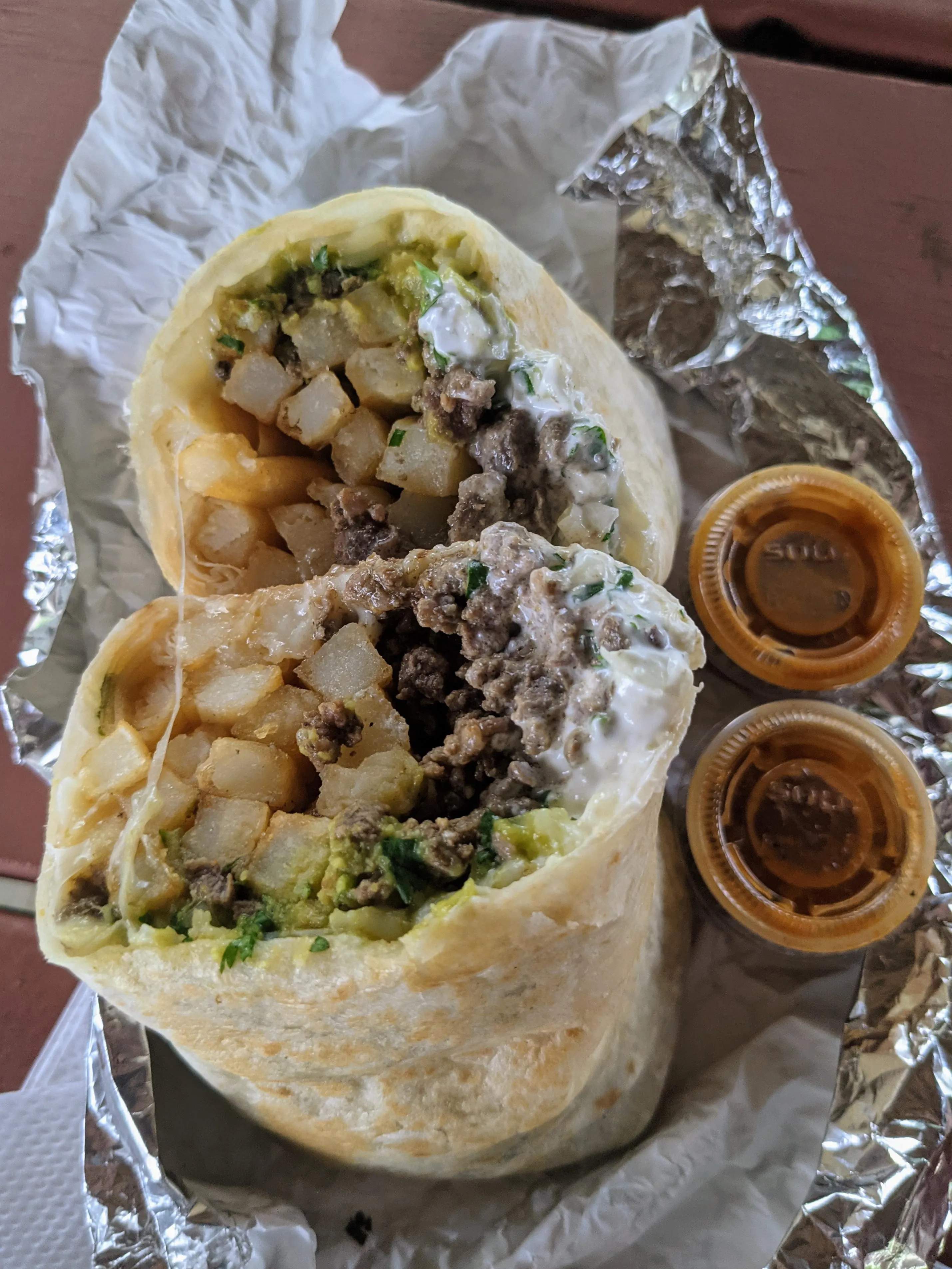 Blackstone California burrito with carne asada, fries, and melted cheese on a grilled flour tortilla