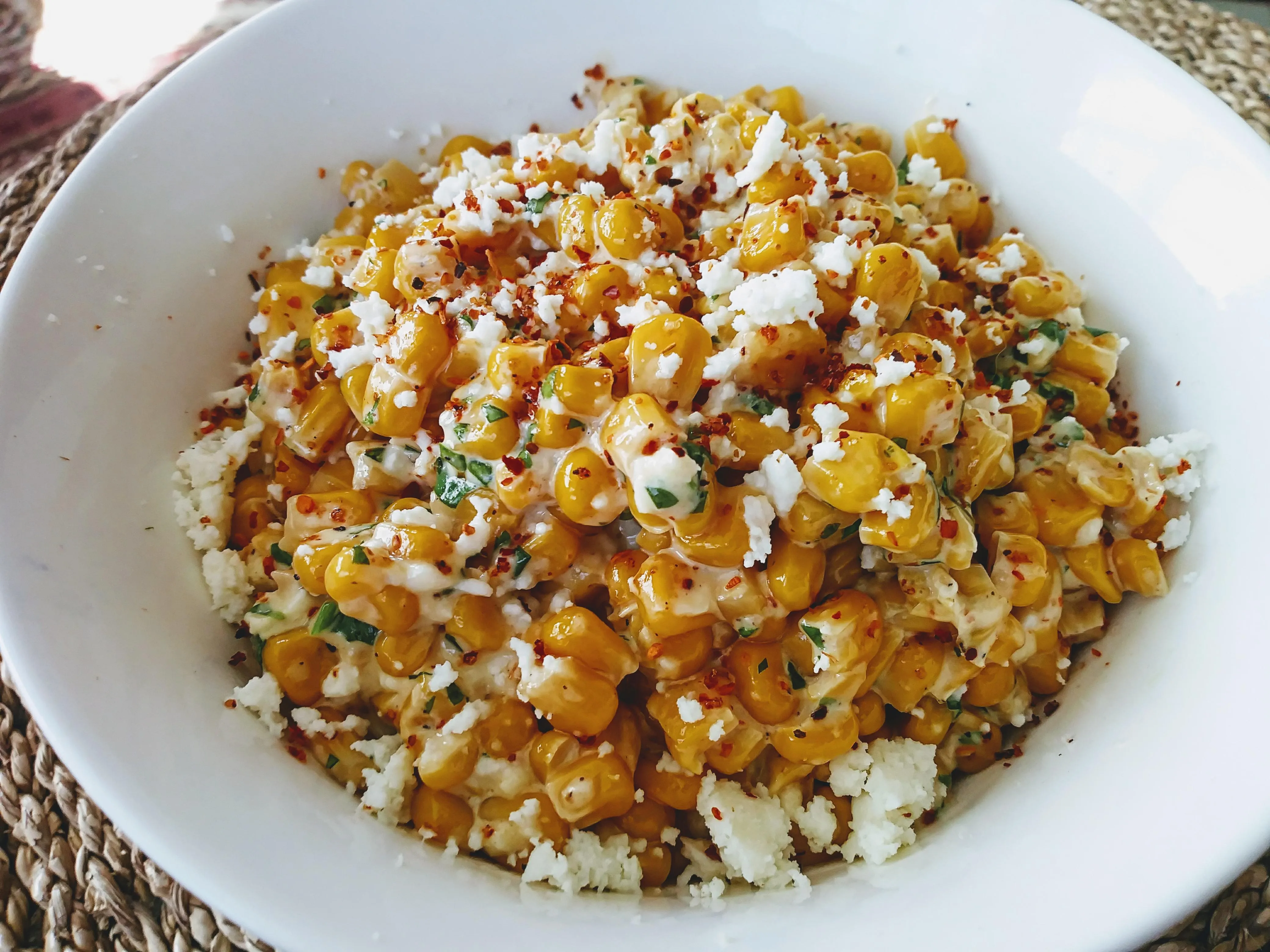 Charred Mexican street corn elotes on a Blackstone griddle with cotija cheese and chili powder