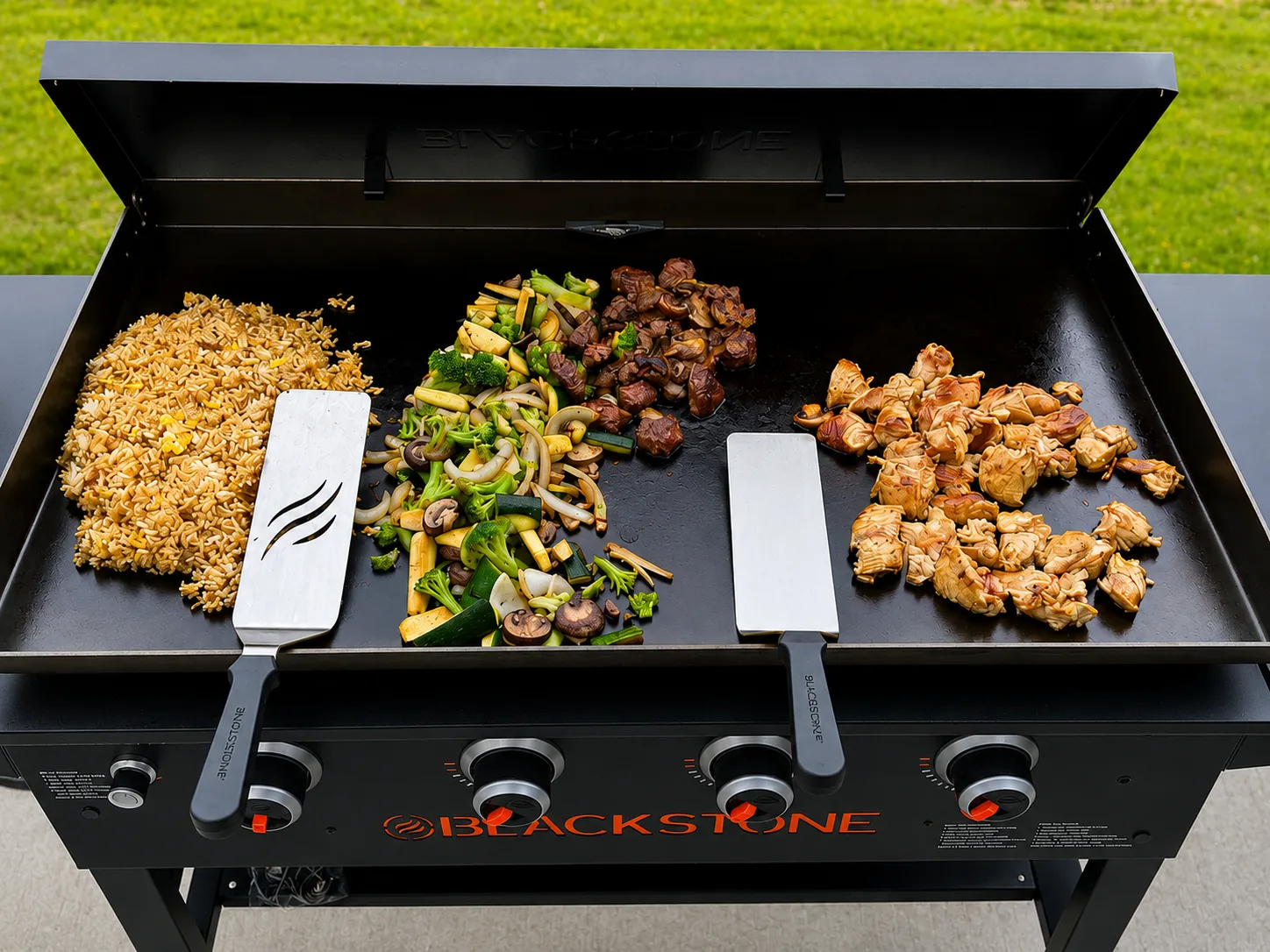 Blackstone hibachi chicken with garlic butter, fried rice, and stir-fried vegetables on the flat-top