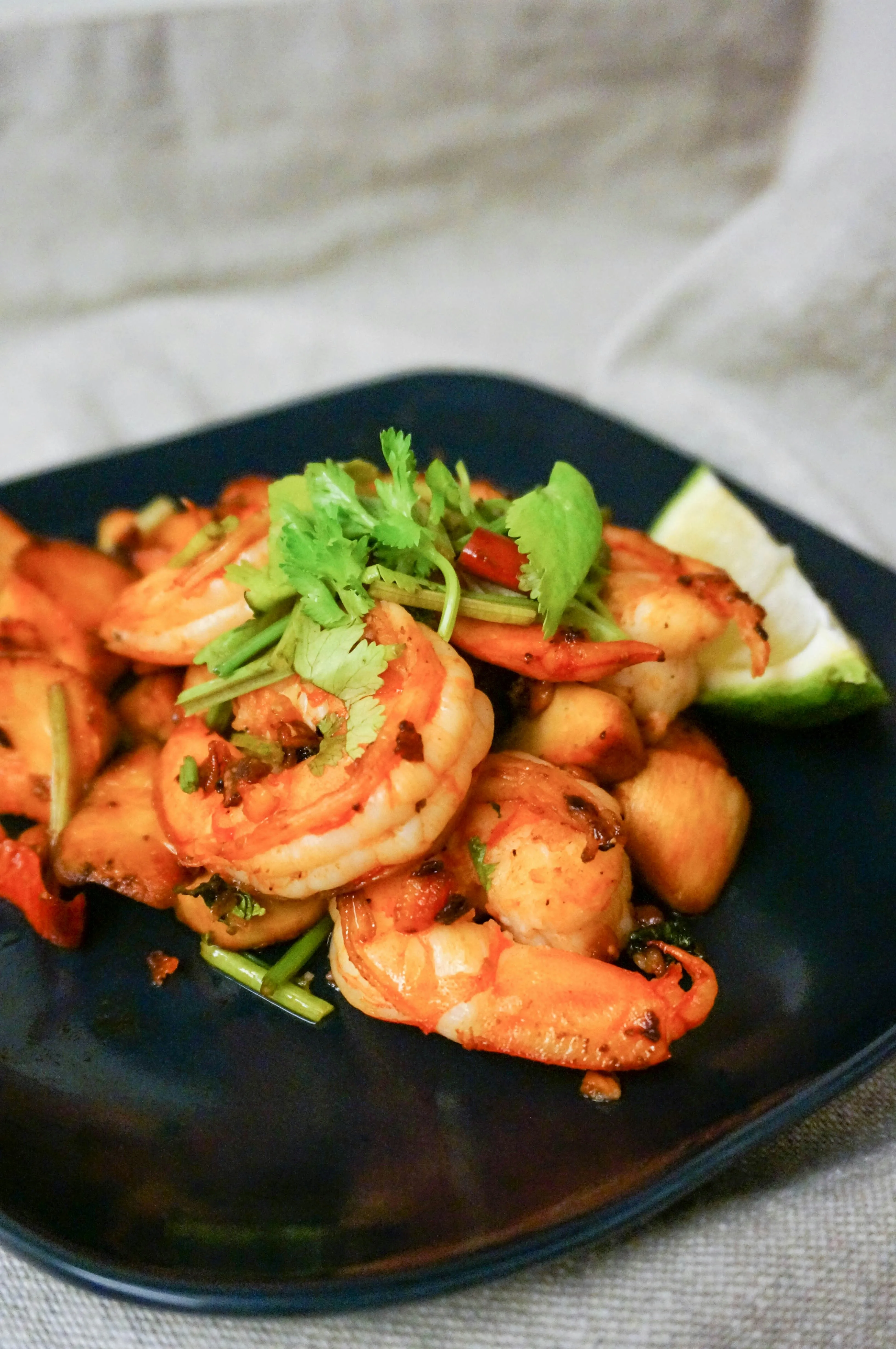 Blackstone shrimp with cilantro and lime on a dark plate