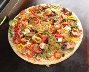 pizza on a blackstone griddle with lots of toppings
